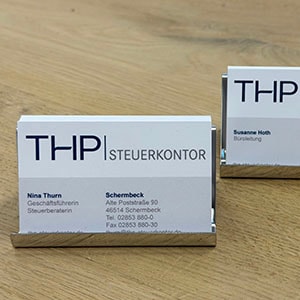 Visitenkarten der THP Steuerkontor auf einem Holztisch